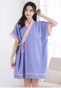 Detailed shot of a purple coral fleece bathrobe with pink trim and cute smile embroidery.