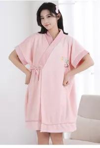 Detailed view of the soft pink coral fleece bathrobe, featuring cute embroidery and V-neck.