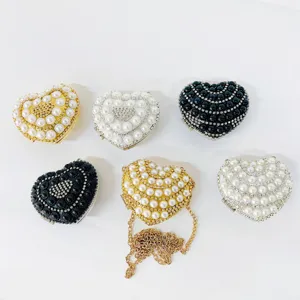 Detail view of heart shaped rhinestone pearl evening clutch bags in multiple colors and styles.