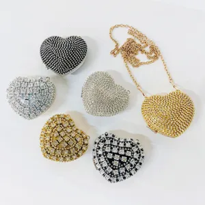 Detailed view of sparkling rhinestone heart evening clutch bags with metallic chain strap design.