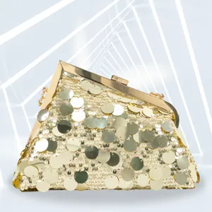 Close-up detail of luxury gold sequin evening clutch bag with metallic frame and shiny sequins.