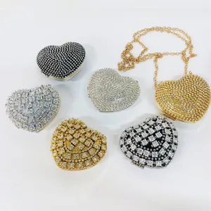 Detailed view of sparkly crystal heart evening clutch bag, shining rhinestone metallic design.