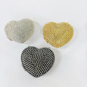 Detail view of three shimmering heart-shaped rhinestone evening clutches in distinct colors.