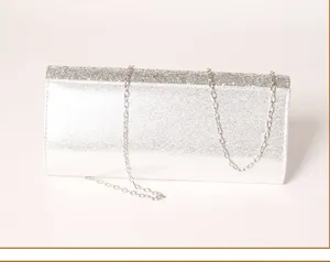 Silver glitter evening clutch bag detail showing sparkling texture and delicate chain strap.