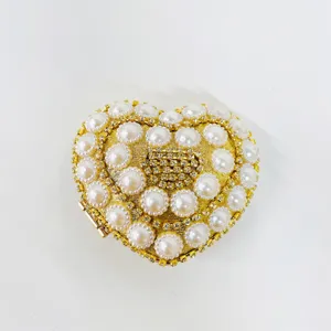 Close-up product detail showcasing the luxury sparkling heart-shaped pearl rhinestone evening bag.