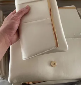 Cream white evening clutch bag detail, PU leather with gold tone metal bar and magnetic snap.