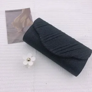 Black evening clutch bag detail shot, elegant pleated design for special events.