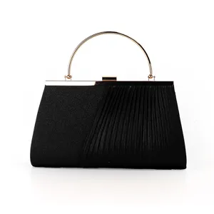 Elegant black evening clutch bag with gold round handle and pleated detail, close-up view