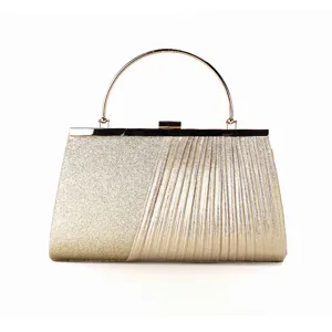 Detailed view of the elegant gold evening clutch with sparkly and pleated design, metal round handle.