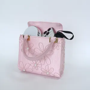 Pink embroidered handbag detail view, elegant floral pattern with pearls for women evening party.