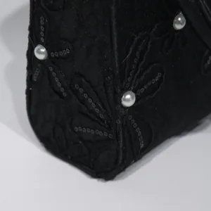 Detailed shot of a black neo-Chinese embroidered evening bag with floral and pearl accents.
