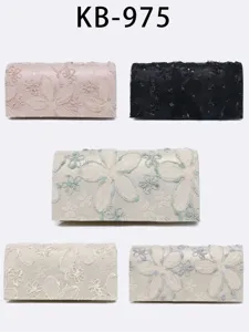 Vista dettagliata di elegante borsa da sera a pochette in pizzo con ricamo floreale e catena.