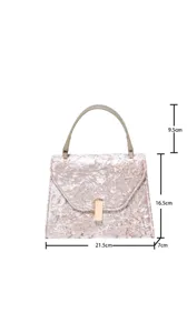 Detail view of the elegant crushed velvet handbag featuring a metal lock and clear dimensions.