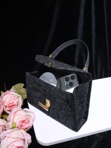 Black textured structured top handle shoulder bag with metal lock and elegant rose decor.