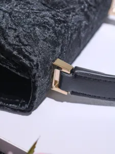 Black textured women shoulder bag detail shot with elegant gold hardware buckle design stylish accessory