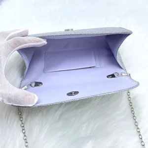 Elegant glitter silver evening clutch bag with chain strap and purple interior detail.