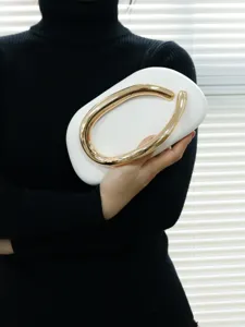 Elegant white evening clutch bag featuring a unique curved gold metal handle for women.