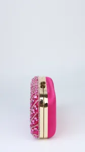 Side view detail of elegant pink rhinestone crystal evening clutch bag with gold metal frame.