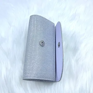 Detailed view of the sparkling silver evening clutch bag with snap closure and glitter finish.