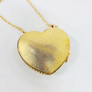 Detailed view of the gold heart-shaped evening bag featuring sparkling texture and chain.