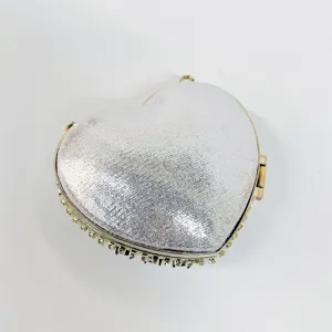 Silver glitter heart evening bag detail, sparkling rhinestone trim and elegant gold metal frame.