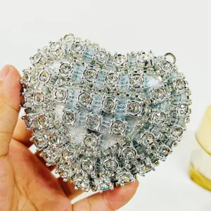 Stunning silver heart-shaped evening clutch bag encrusted with sparkling rhinestones for women.
