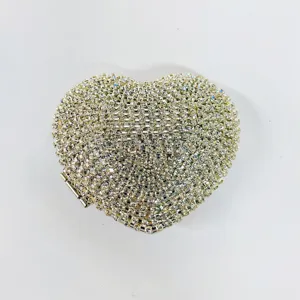 Closeup detail of sparkling crystal rhinestone heart evening clutch bag with metal clasp hardware.