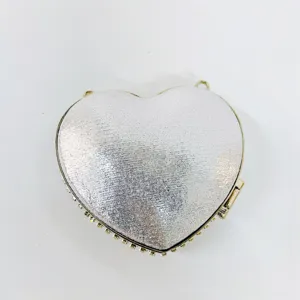 Detailed view of the silver sparkly heart clutch bag with rhinestone trim and gold frame.