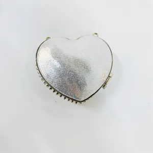 Detailed close-up of the shimmering silver heart-shaped evening clutch with crystal trim.