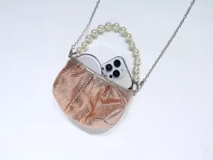 Sparkling rhinestone evening bag detail, elegant pearl handle and metal chain strap.