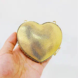 Gold heart-shaped clutch evening bag, stunning metallic finish, stylish party handbag detail.