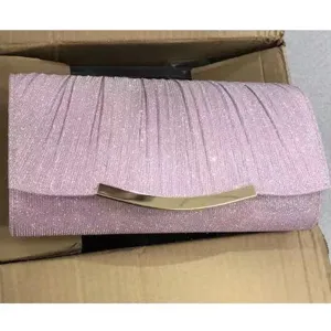 Close-up detail of a sparkling pink glitter evening clutch bag with elegant metal lock hardware.