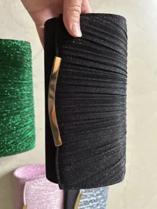 Details of the black glitter pleated clutch bag with gold metal clasp, stylish evening purse.