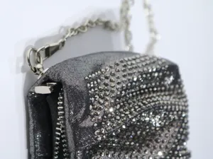 Detailed view of the sparkling rhinestone evening clutch bag with metallic chain strap.