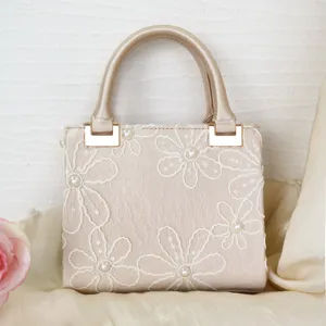 Elegant embroidered evening handbag with pearl accents and top handle for women.