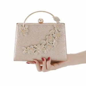 Elegant gold glitter evening clutch bag with rhinestone flowers and metal ring handle.