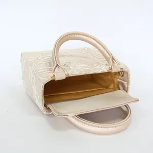 Elegant champagne embroidered evening handbag with delicate floral pearl details, stylish.