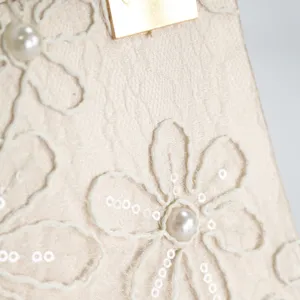 Detail of Chinese style embroidered women evening bag with floral pattern and pearl decor.