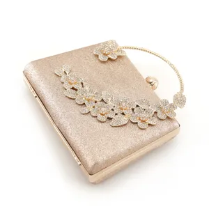 Elegant gold glitter evening clutch bag with sparkling rhinestone floral design for women.