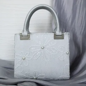 Silver embroidered handbag evening bag with pearl floral detail, stylish daily accessory.