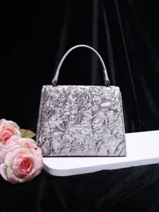 Detail view of the silver crinkled velvet top-handle bag showcasing texture and craftsmanship.