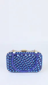 Blue rhinestone evening clutch bag detail showing sparkling crystals and gold metal frame lock.