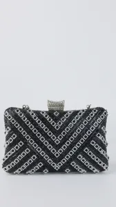 Close-up detail of the black crystal embellished evening clutch bag with sparkling metal clasp.