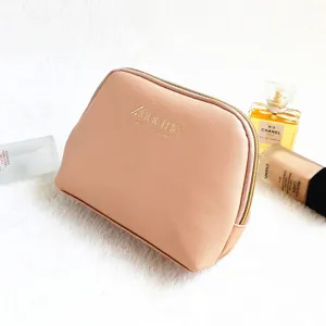 Detailed view of the elegant pink cross-grain leather cosmetic pouch featuring gold zipper.
