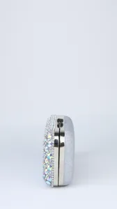Detail view of a silver glitter evening clutch bag, featuring sparkling rhinestones and metal frame.