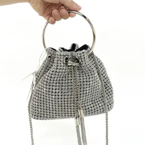 Sparkling rhinestone bucket bag detail, stylish metallic round handle and tassel.