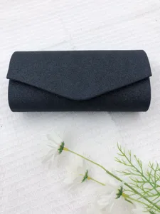 Close-up detail of the black glitter evening clutch bag showing fine sparkling fabric texture.