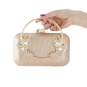 Elegant gold glitter evening clutch bag with sparkling crystal leaf handle for weddings.