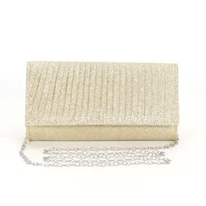 Dettaglio clutch da sera glitterata dorata con tessuto luminoso e catena argentata.