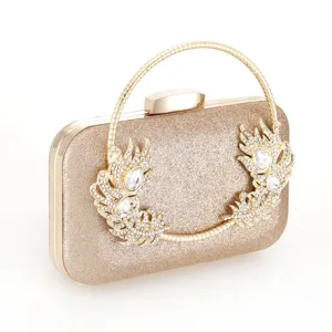 Gold glitter evening clutch bag close up detail, featuring metallic handle and sparkling rhinestones.